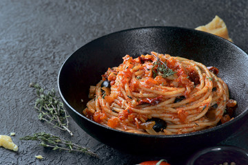 Pasta with tomato sauce, sun-dried tomatoes and olives