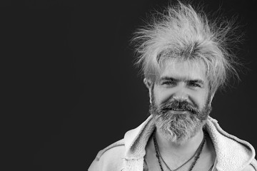 Goofy young man, with full beard and moustache and wild hair, pull a comical face to the camera....