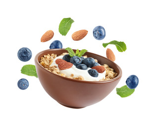 Tasty oatmeal with blueberries, yogurt and almond on white background