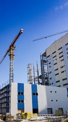 Industrial engineering. Factory on a background of blue sky. Construction technology. Cranes.