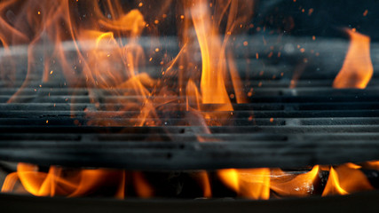 Empty flaming cast iron grate charcoal grill with open fire, ready for product placement.