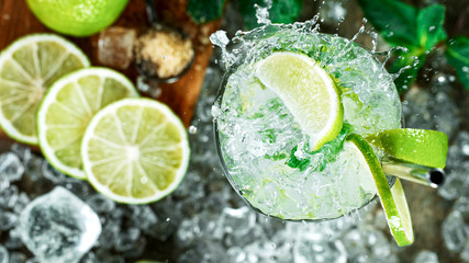 Top view shot of fresh mojito cocktail with fresh lime and mint leaf on black stone background,...