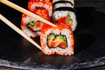 Beautiful and delicious variety of sushi rolls laid out on a stone board. - 344613119