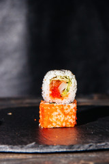 Beautiful and delicious variety of sushi rolls laid out on a stone board. - 344613301