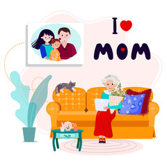 Family call aged Mother to congratulate her with Happy mothers day. Phrase I Love MOM for Mommy day. Old woman has distant call with son, his wife and grandkid in her Birthday. Senior sit in cozy sofa
