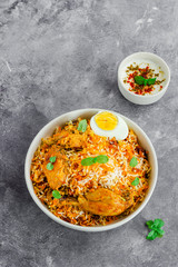 Vertical Photo of Chicken Biryani with Raita in the Background, Traditional Indian Rice and Chicken One Pot Dish
