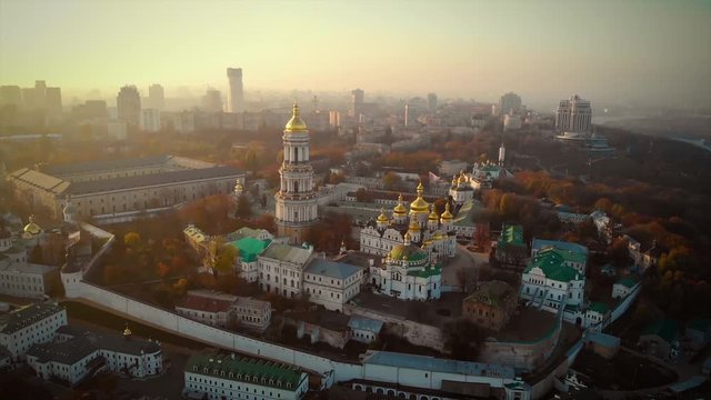 Panorama of Kiev near the Kiev-Pechersk Lavra at sunset in the fog. Aerial view of Kiev Pechersk Lavra in autumn, Kiev, Kyiv, Ukraine. Beautiful orange tones, 4k video. Camera moves back. Aerial view.