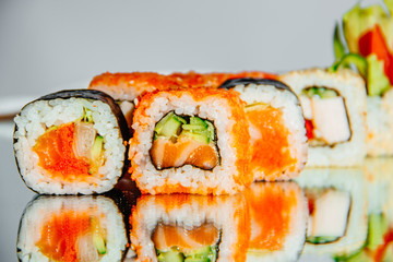 Beautiful sushi set on laid out on a mirrored table, the background is blurred - 344614109