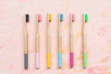 Natural wooden bamboo toothbrushes. Plastic free and zero waste concept. Top view, pink...