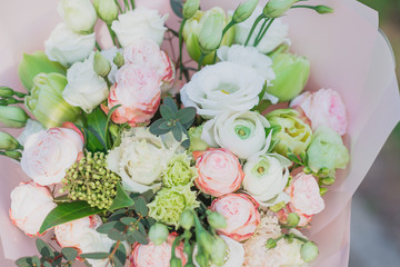 beautiful tender flowers bouquet of cream roses and pink Ranunculus asiaticus and white Eustoma...