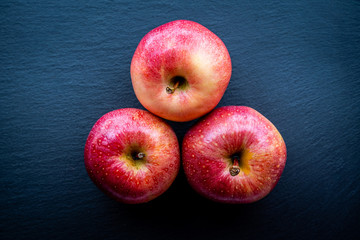 Top view of some fresh red apples on a dark background. Concept of healthy and natural food.