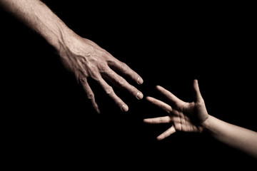 Hands reaching out to each other on dark black background