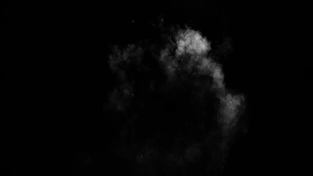 Dusty bullet hits on a wall with chunks of debris flying out . Powder explosion on black background. Impact dust particles. Dust explosion in front of black background, slow-motion close up. VFX. Dust