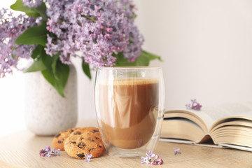 Composition with chocolate chip cookies, cocoa and lilac on wooden table