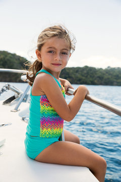 Young girl sitting down by the rail of a boat in Costa Rica.