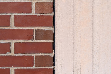 Brick wall next to a poured exterior concrete wall with expansion joint