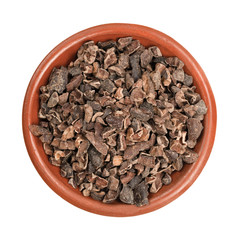 Top view of a small bowl of cocoa nibs on a white background