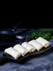 Raw rolled pancakes with filling ready to be roasted