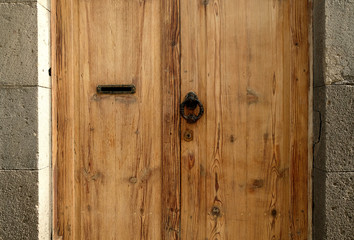 Classic wooden door with mailbox slot and ornamental calssic door knocker.