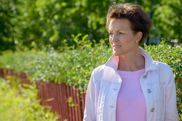 Face of happy mature beautiful woman thinking in nature outdoors