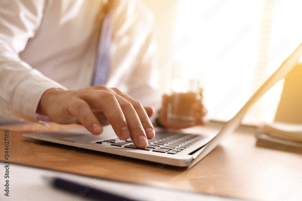 Wall mural man working with laptop at table in office, closeup