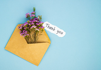 a bouquet of spring wildflowers in an envelope and the inscription thank you