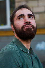Obraz premium Portrait of young guy with dark beard with various emotions on his face in green shirt.