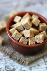 Selective focus. Macro. Brown sugar cubes. Brown sugar in a bowl. Copy space.