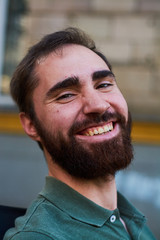 Obraz premium Portrait of young guy with dark beard with various emotions on his face in green shirt.
