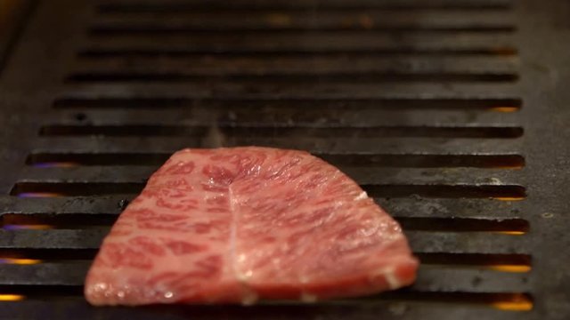 Thinly sliced Japanese wagyu beef on grille for barbecue. Grill one of the best beef in Japan. Style Yakiniku meaning grilled meat cuisine. BBQ food.-Dan