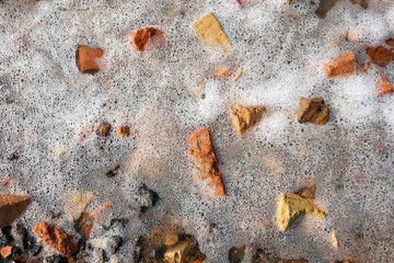 bubbles of white foam in stones at sea