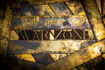 Photo of real authentic typeset letters forming War Zone text on vintage textured grunge copper and gold background
