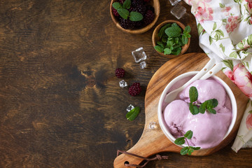 Homemade Organic Ice Cream with Mint. Blackberry ice cream in white bowl on a rustic table. Top view flat lay background. Copy space.