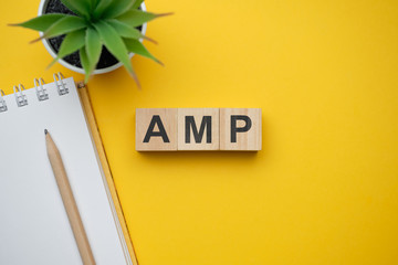 Modern marketing buzzword AMP - Accelerated Mobile Pages. Top view on wooden table with blocks. Top view.