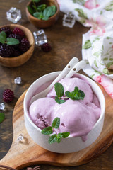 Homemade Organic Ice Cream with Mint. Blackberry ice cream in white bowl on a rustic table.