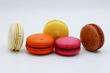 Pink, white, yellow, brown and orange macarons. White background.