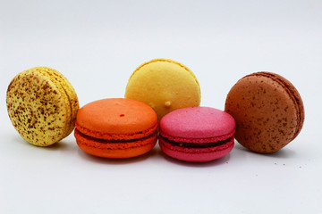 Pink, yellow, brown and orange macarons. White background.