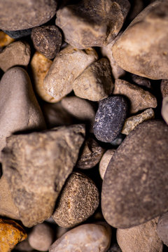 Dark stone in a pile o light stones