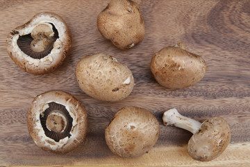 Flat lay fresh organic brown mushrooms champignon on a wooden board. Top view.