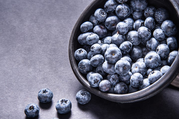 Fresh blueberries in black ceramic bowl