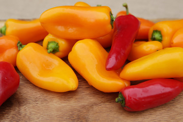 Close-up organic red and yellow sweet or chili peppers on a wooden table
