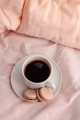 A Morning drink with macaroons in a bed. Romantic breakfast and letter.