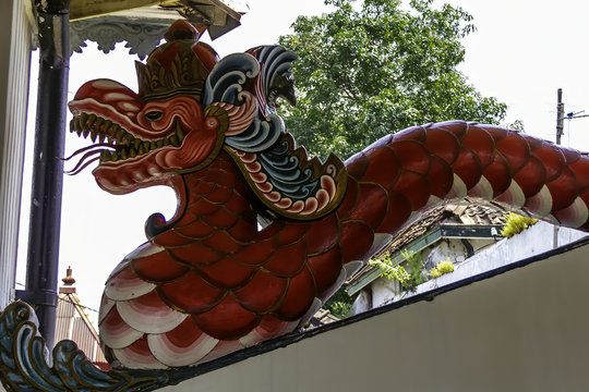 Reddish Dragon Snake called naga sculpted in stone to decorate a temples. Yogyakarta, Island of Java