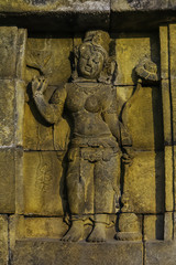 Fototapeta na wymiar Sculped ancient lady with long hair in the wall of Borobudur temple located at Magelang, Central Java, Indonesia
