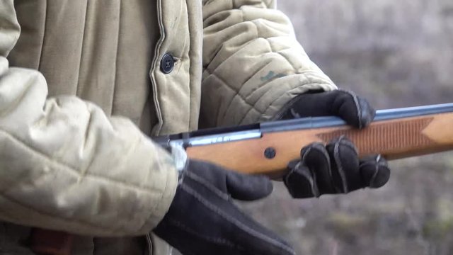 Man wearing Loads a gun weapon inserts ammo to a sawn-off shotgun with a sound