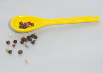 Yellow spoon whit pepper