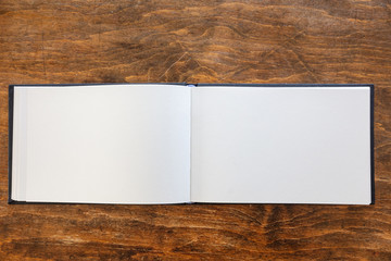Blank open notebook template on wood, top view