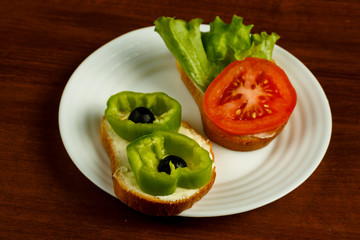 White plate with vegetarian sandic on a wooden table.