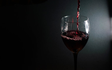 Obraz na płótnie Canvas Pour red wine into a glass