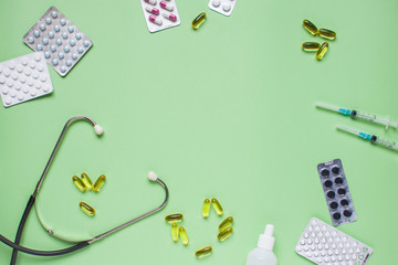 Stethoscope, syringes and pills. Medicine. Layout. Green background